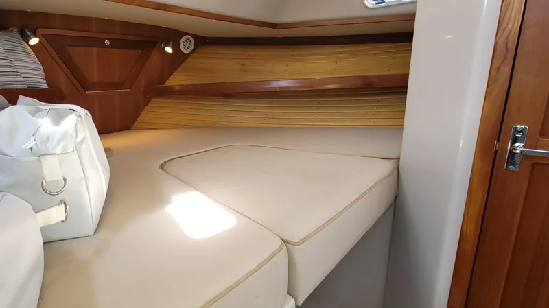 Slide: The Image of Interior of 2015 Eastport 32 OBX with cozy bed and wooden walls. - 12