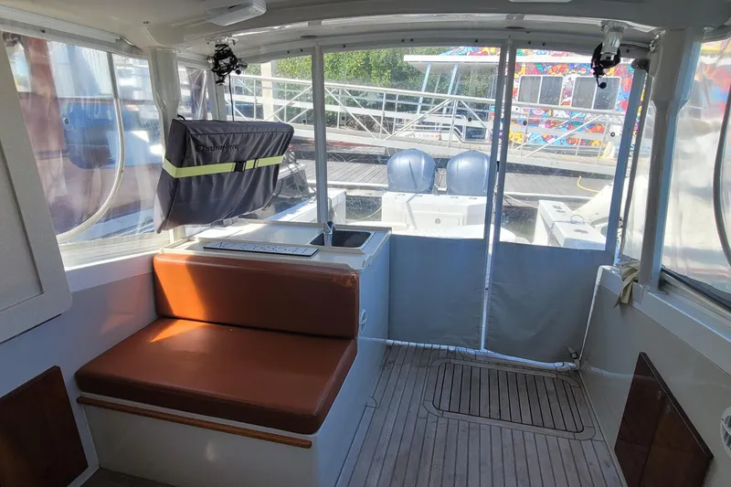 Slide: The Image of Interior of 2015 Eastport 32 OBX boat with seating and dock view. - 17