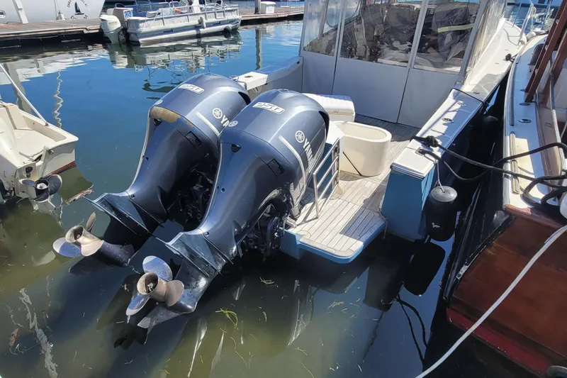 Slide: The Image of Twin Yamaha outboard engines on a 2015 Eastport 32 OBX boat docked at a marina. - 20