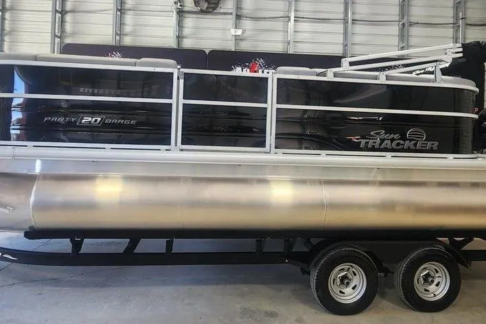The Image of 2026 Sun Tracker Party Barge 20 DLX pontoon boat in a garage setting. - 1