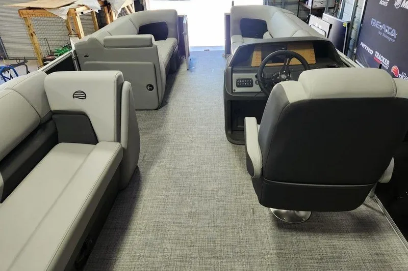 Slide: The Image of Interior of 2026 Sun Tracker Party Barge 20 DLX with gray seating and steering console. - 11