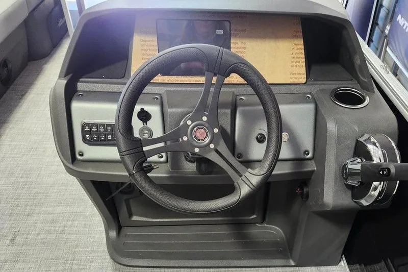 Slide: The Image of Steering console of 2026 Sun Tracker Party Barge 20 DLX with modern controls and cup holder. - 5