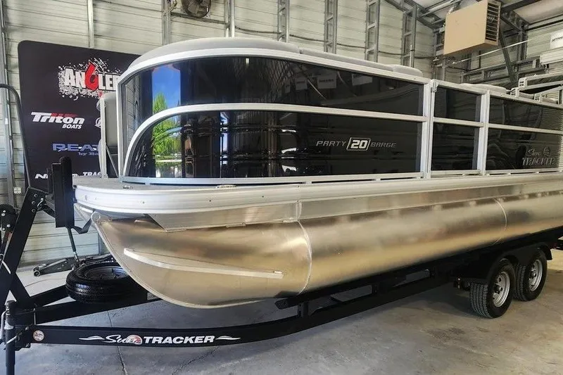 Slide: The Image of 2026 Sun Tracker Party Barge 20 DLX pontoon boat on trailer in showroom. - 7