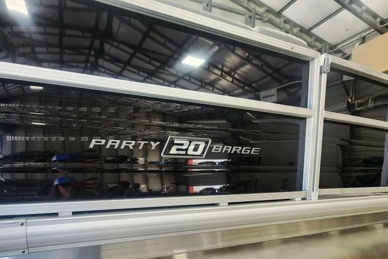 Slide: The Image of 2026 Sun Tracker Party Barge 20 DLX pontoon boat in a storage facility. - 9