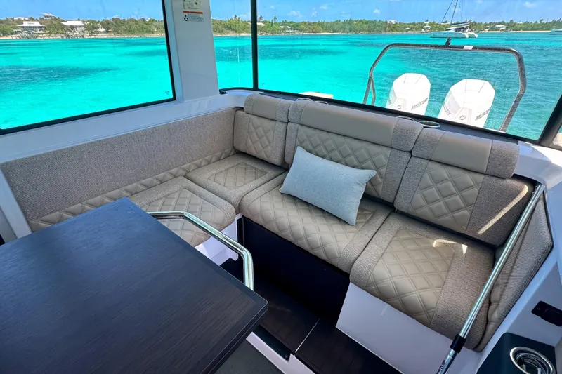 Slide: The Image of Luxurious interior of 2025 Axopar 37 XC Cross Cabin with quilted seating and scenic ocean view. - 11