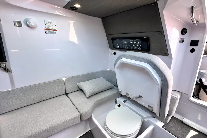 Slide: The Image of 2025 Axopar 37 XC Cross Cabin interior with modern seating and compact toilet. - 14