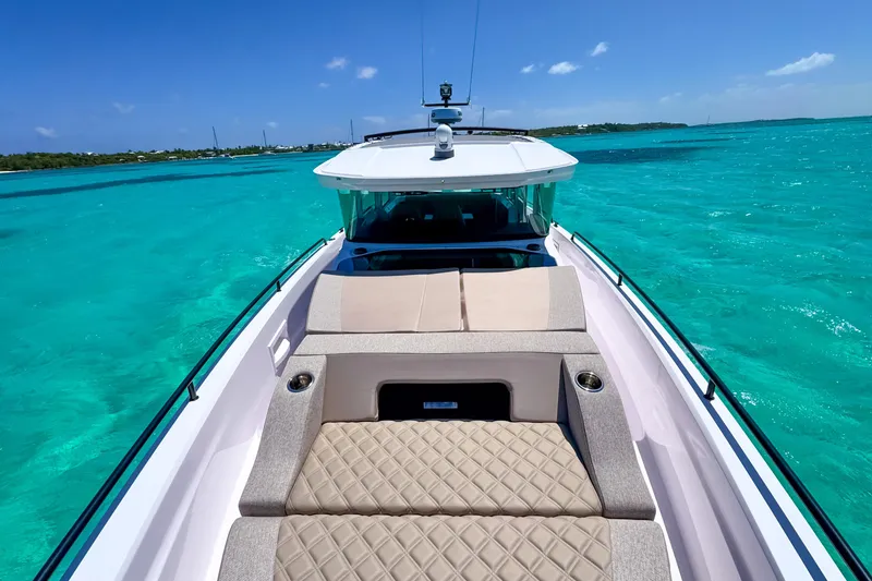 Slide: The Image of 2025 Axopar 37 XC Cross Cabin cruising on clear turquoise waters. - 15