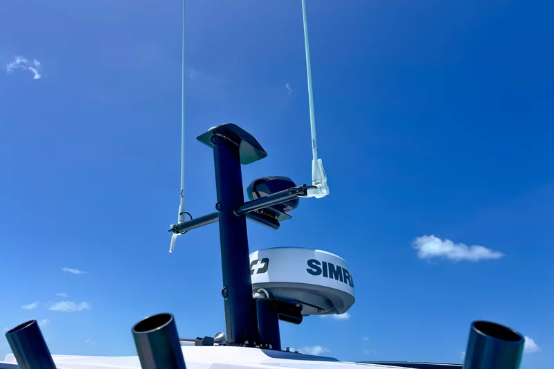 Slide: The Image of Antenna and radar on 2025 Axopar 37 XC Cross Cabin against clear blue sky. - 17