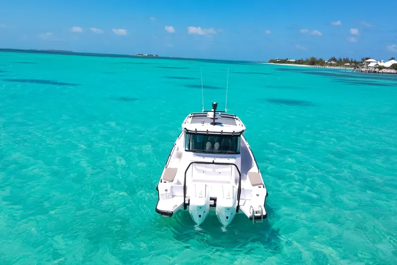 Slide: The Image of 2025 Axopar 37 XC Cross Cabin on turquoise waters, clear sky background. - 3