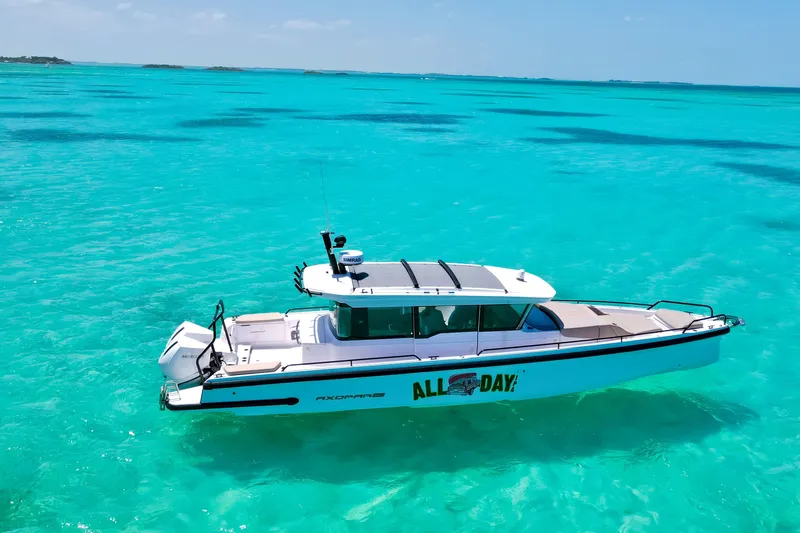 Slide: The Image of 2025 Axopar 37 XC Cross Cabin boat on clear turquoise water. - 4