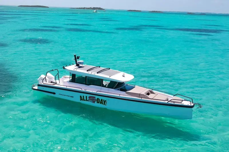 Slide: The Image of 2025 Axopar 37 XC Cross Cabin boat on clear turquoise water. - 5