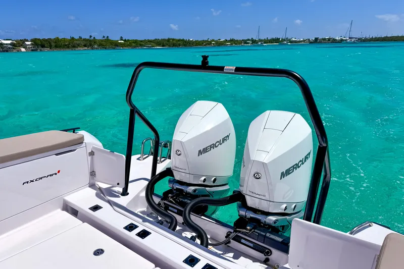 Slide: The Image of 2025 Axopar 37 XC Cross Cabin with twin Mercury engines on turquoise water. - 6