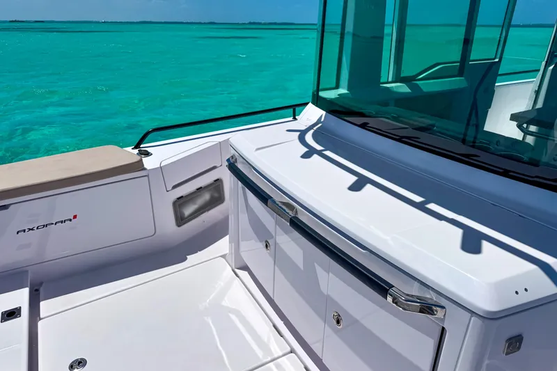 Slide: The Image of 2025 Axopar 37 XC Cross Cabin boat on turquoise water, showcasing sleek design. - 7