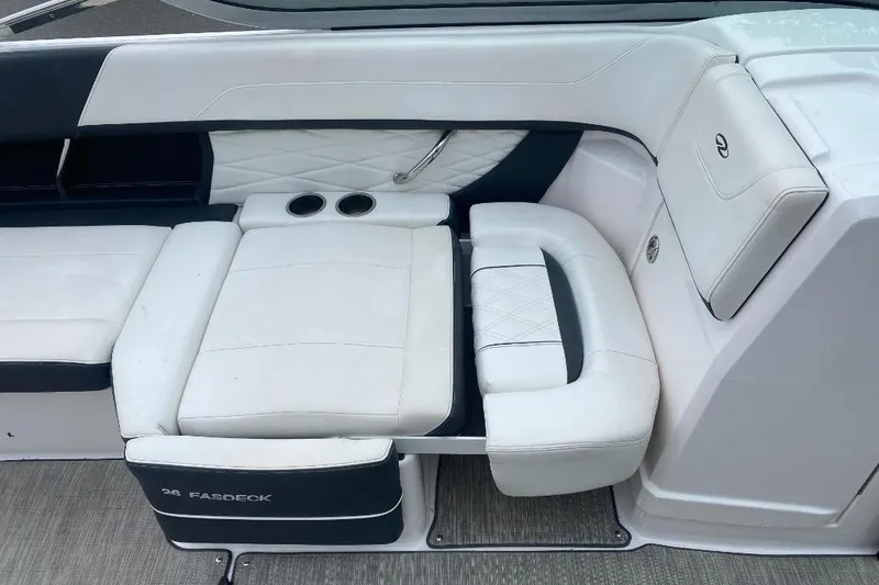 Slide: The Image of 2018 Regal 26 FasDeck boat interior with white cushioned seating and cup holders. - 11