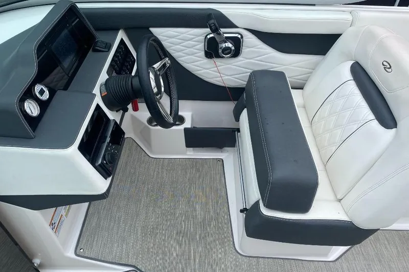 Slide: The Image of 2018 Regal 26 FasDeck boat interior with steering wheel and cushioned seating. - 12