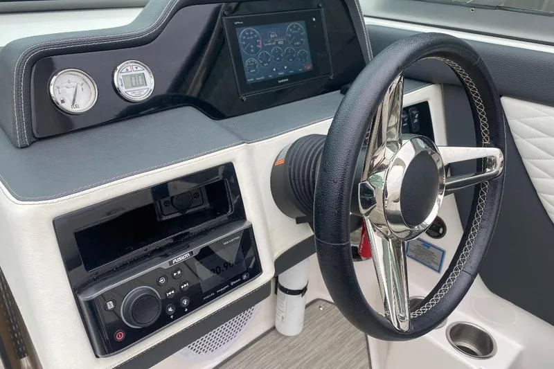 Slide: The Image of Dashboard of a 2018 Regal 26 FasDeck boat with steering wheel and controls. - 13