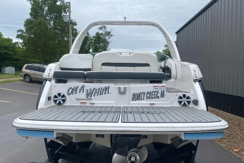 Slide: The Image of 2018 Regal 26 FasDeck boat with "On a Whim" text, parked outdoors. - 3