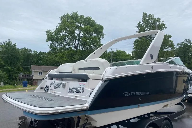 Slide: The Image of 2018 Regal 26 FasDeck boat with sleek design, parked outdoors. - 4