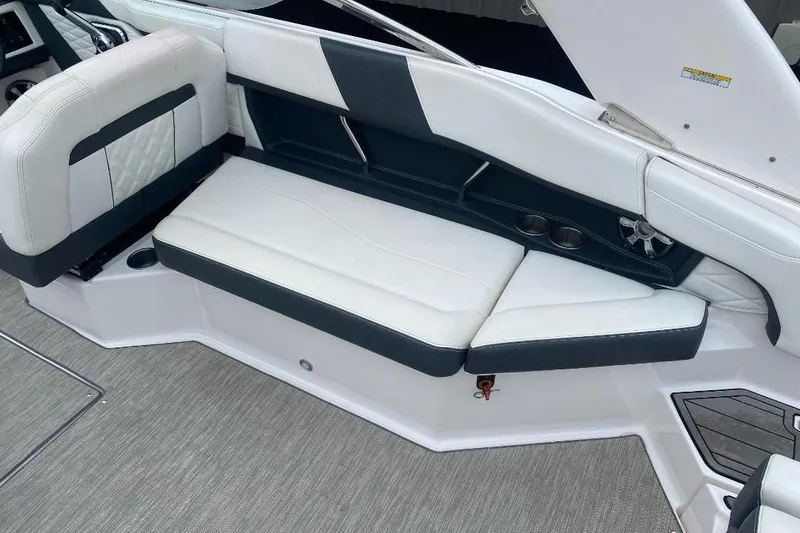 Slide: The Image of 2018 Regal 26 FasDeck boat interior with white and black seating and cup holders. - 9