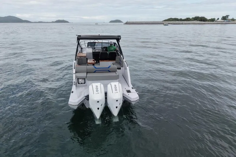 Slide: The Image of 2027 Hanover 327 boat with dual engines on calm water, distant islands visible. - 2