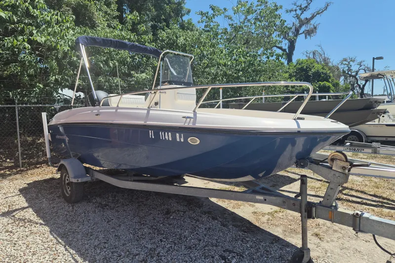 The Image of 2017 Bayliner Element F18 boat on trailer, parked outdoors with trees in background. - 1