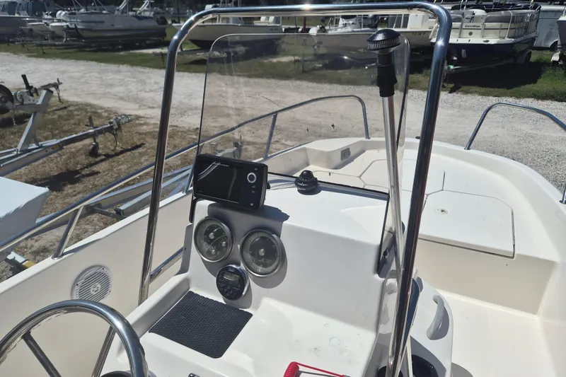 Slide: The Image of 2017 Bayliner Element F18 boat dashboard with steering wheel and gauges in a marina setting. - 11