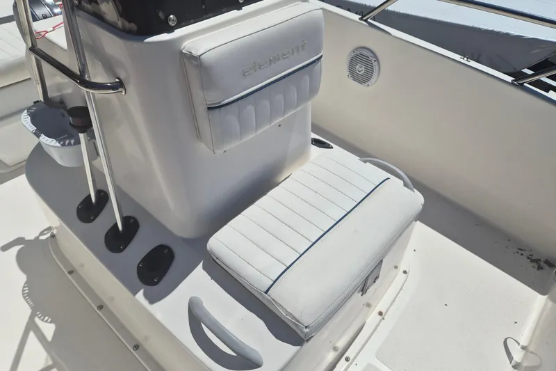 Slide: The Image of 2017 Bayliner Element F18 boat interior with cushioned seating and console. - 13