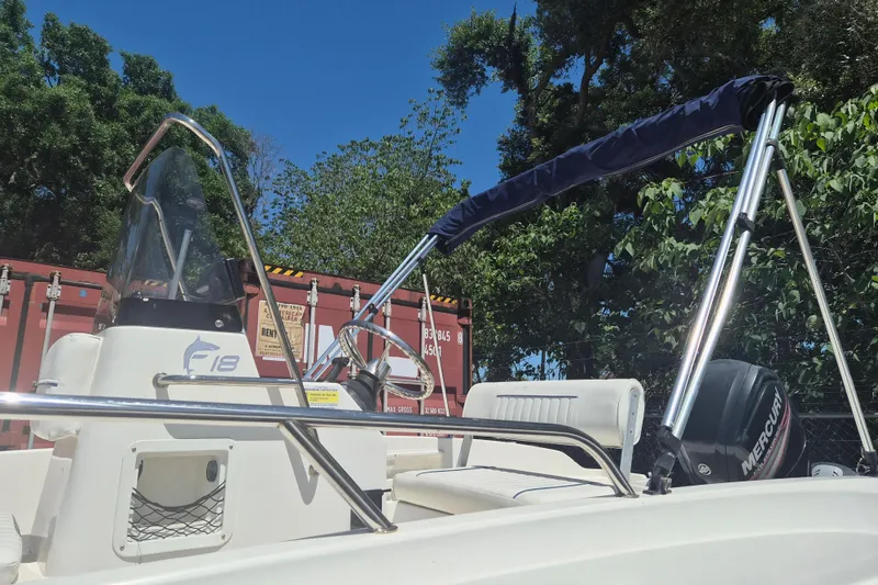 Slide: The Image of 2017 Bayliner Element F18 boat with canopy and steering wheel, outdoors. - 20