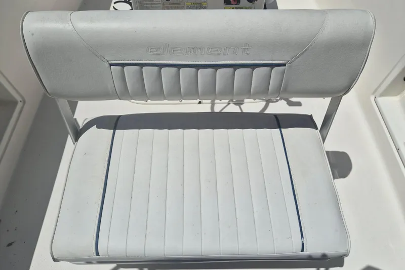 Slide: The Image of 2017 Bayliner Element F18 boat seat with embossed logo, white and blue upholstery. - 6