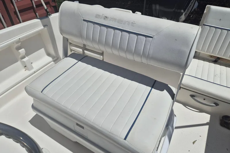 Slide: The Image of 2017 Bayliner Element F18 boat seat with white upholstery and blue accents. - 7