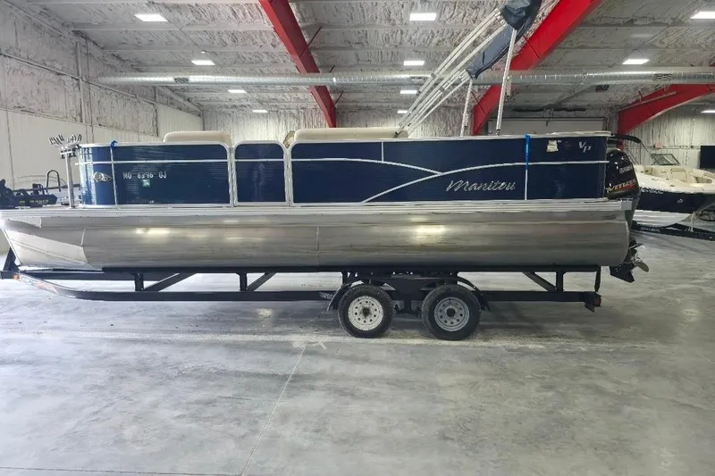 The Image of 2018 Manitou 22 Aurora LE Angler pontoon boat on trailer in indoor storage. - 1