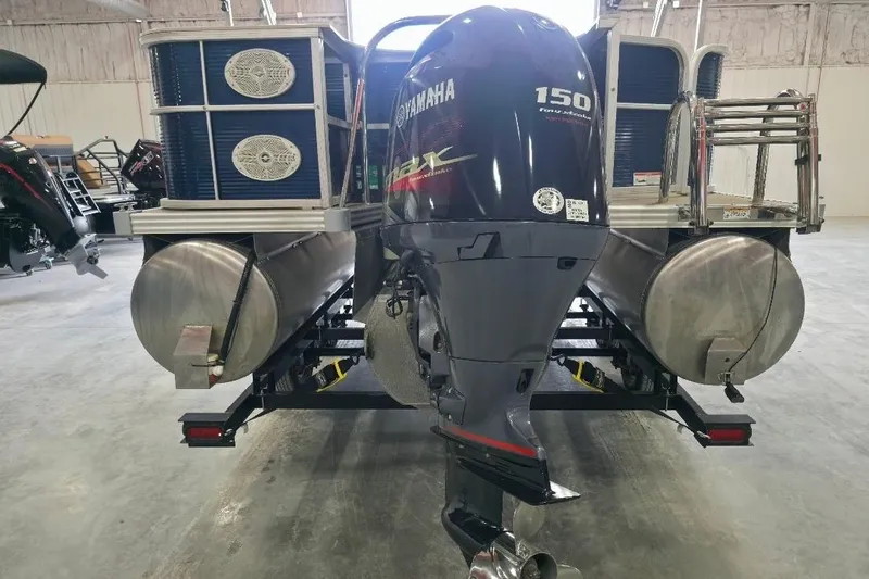 Slide: The Image of 2018 Manitou 22 Aurora LE Angler with Yamaha 150 outboard motor in a warehouse setting. - 5