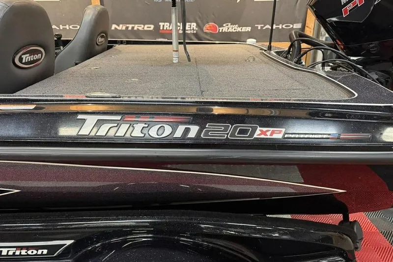 Slide: The Image of 2025 Triton 20XP Patriot boat, sleek design, black finish, visible branding. - 14