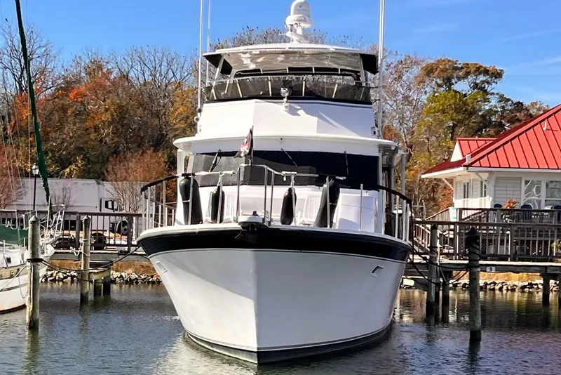 Slide: The Image of 1985 Hartman-Palmer 60 Flush Deck Motor Yacht docked near a red-roofed building. - 2