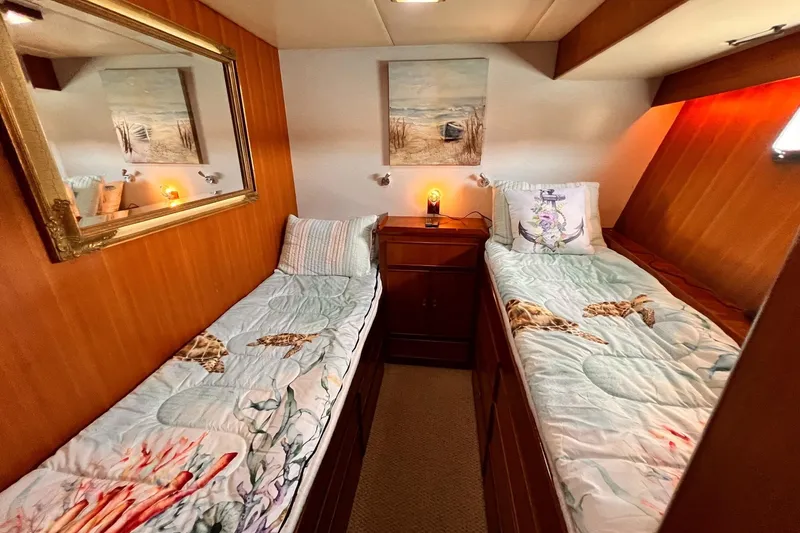 Slide: The Image of Cozy twin cabin in 1985 Hartman-Palmer yacht with nautical decor and warm lighting. - 50