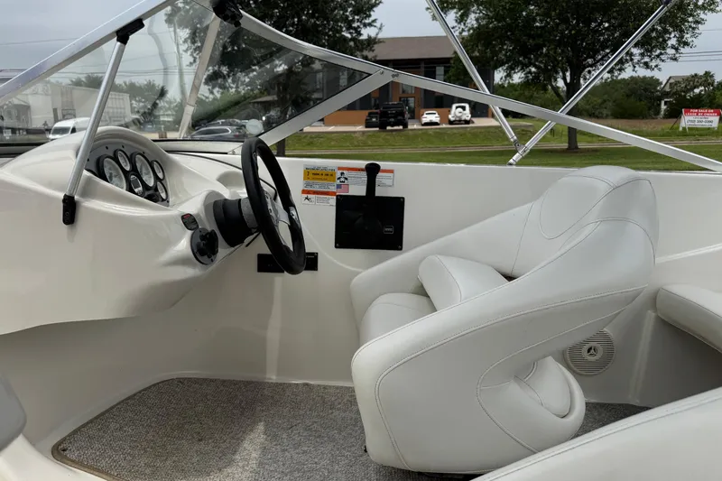 Slide: The Image of 2008 Glastron MX 175 boat interior with steering wheel and white seating. - 11