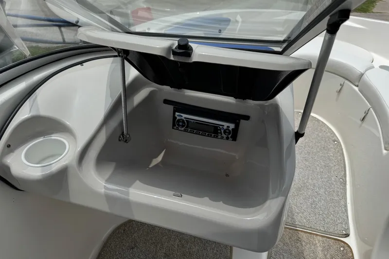Slide: The Image of 2008 Glastron MX 175 boat dashboard with open glove compartment and stereo system. - 19