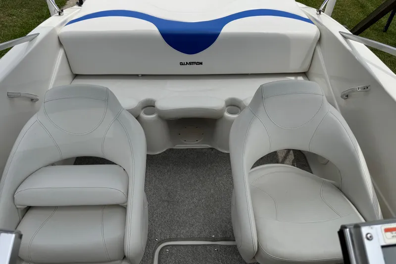 Slide: The Image of Interior of a 2008 Glastron MX 175 boat with white seating and blue accents. - 20