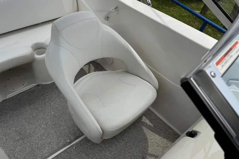 Slide: The Image of White seat in a 2008 Glastron MX 175 boat, featuring gray carpet and cup holder. - 22