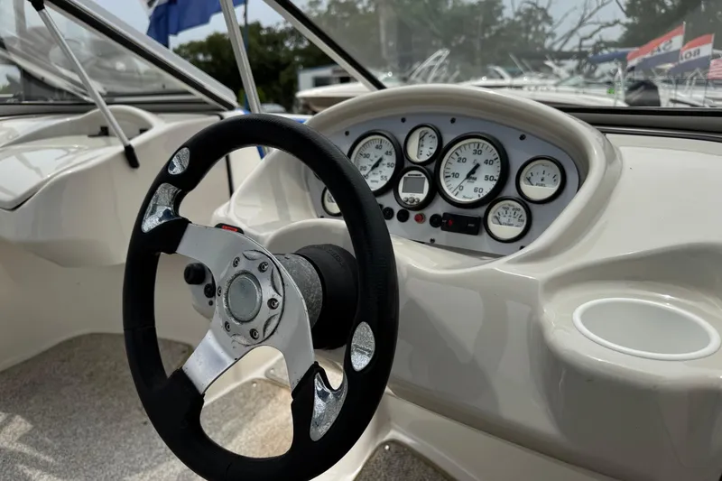 Slide: The Image of Steering wheel and dashboard of 2008 Glastron MX 175 boat, featuring gauges and controls. - 4