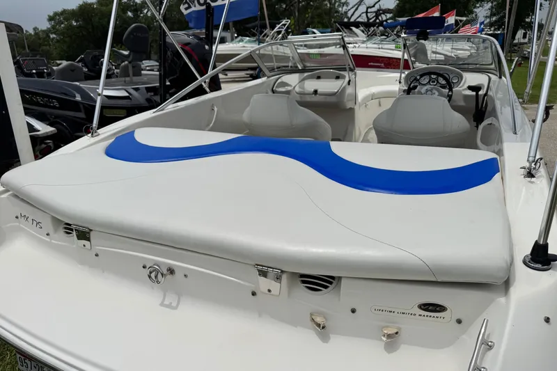 Slide: The Image of 2008 Glastron MX 175 boat with white and blue seating, displayed outdoors. - 8