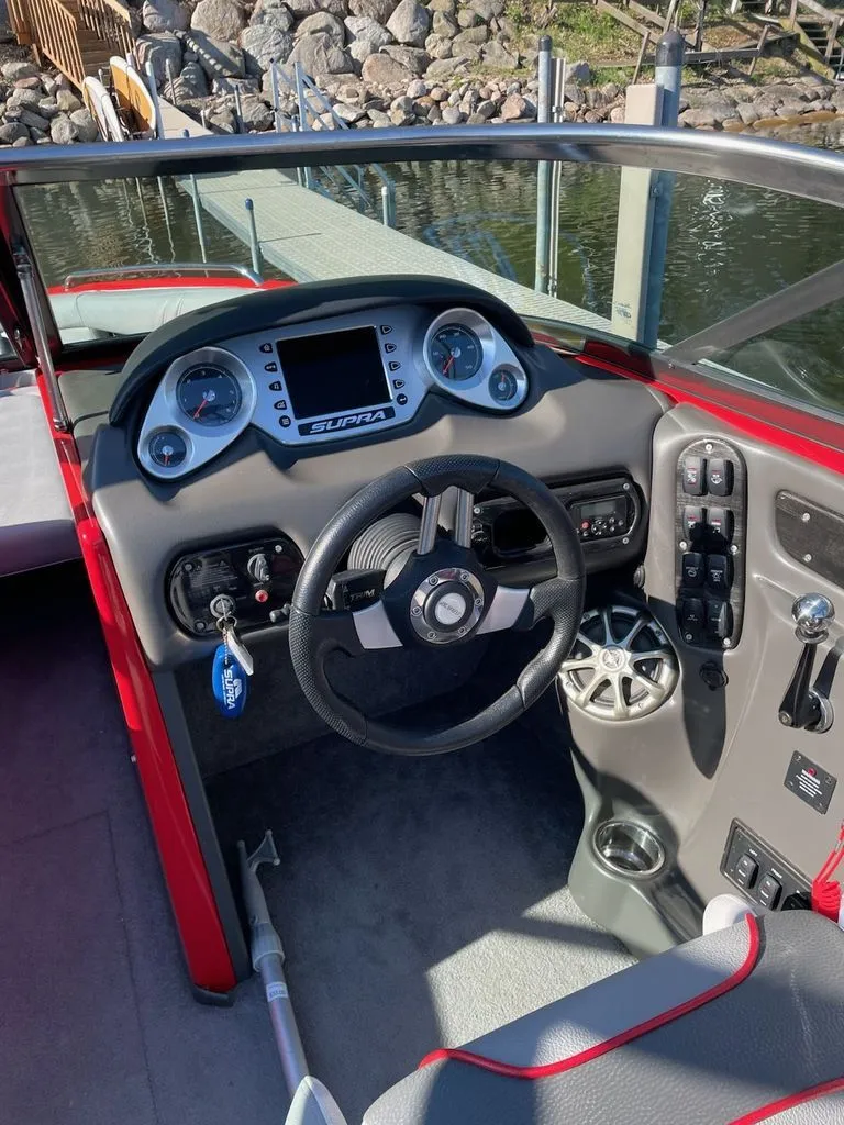 Slide: The Image of Interior of a 2011 Supra Sunsport boat with steering wheel and dashboard. - 4