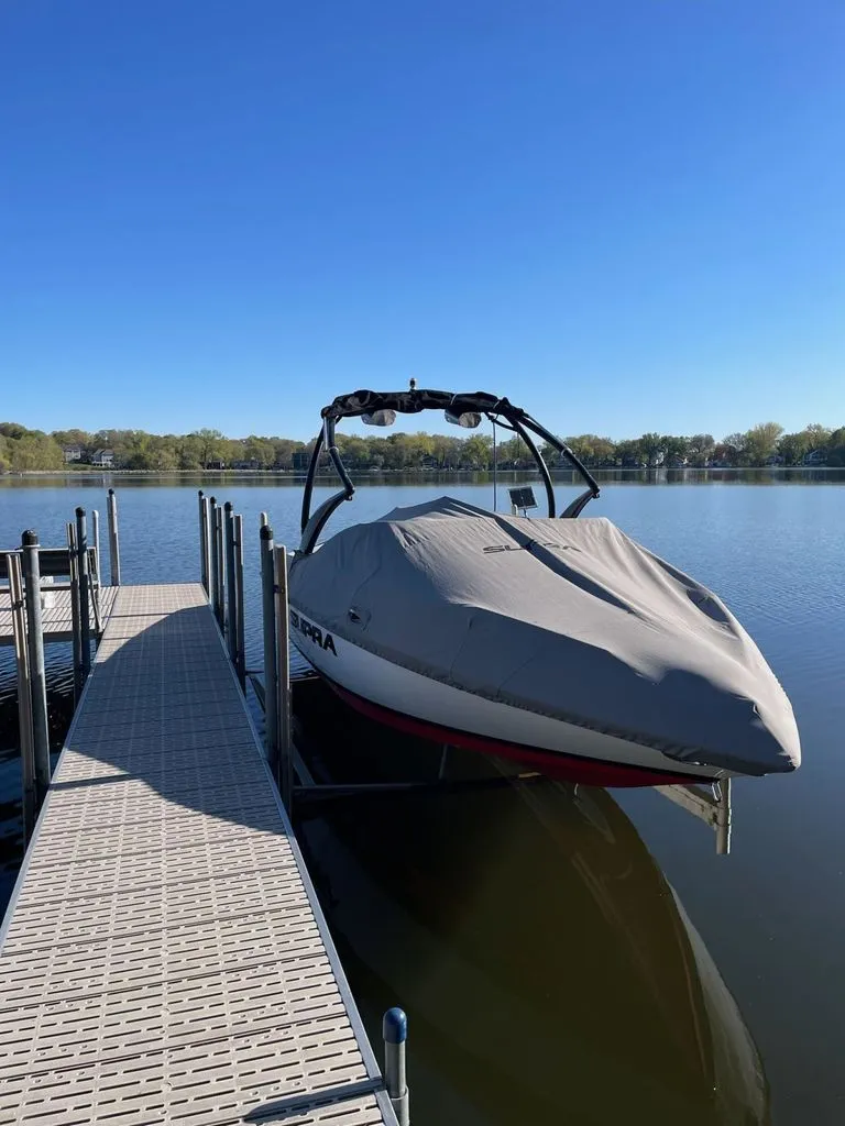 Slide: The Image of 2011 Supra Sunsport boat docked on a calm lake. - 5