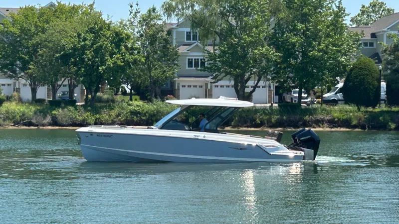 Slide: The Image of 2025 Monterey Elite 30 OB on calm water near houses. - 5