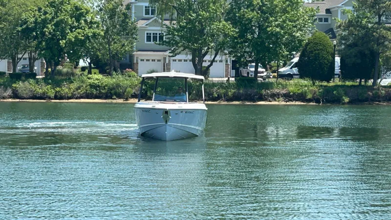 Slide: The Image of Monterey Elite 30 OB 2025 on calm water near houses. - 7