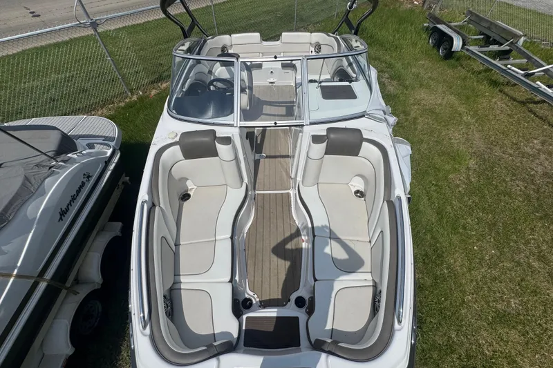 Slide: The Image of 2013 Yamaha Boats 242 Limited S with spacious seating, parked on grass near a trailer. - 15