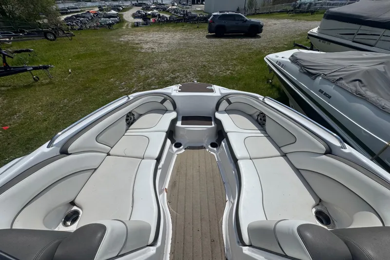 Slide: The Image of 2013 Yamaha Boats 242 Limited S, covered, parked on grass, rear view. - 2