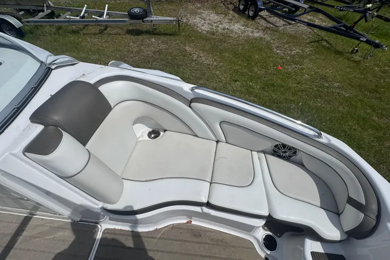 Slide: The Image of 2013 Yamaha Boats 242 Limited S interior with seating and steering wheel, parked outdoors. - 4