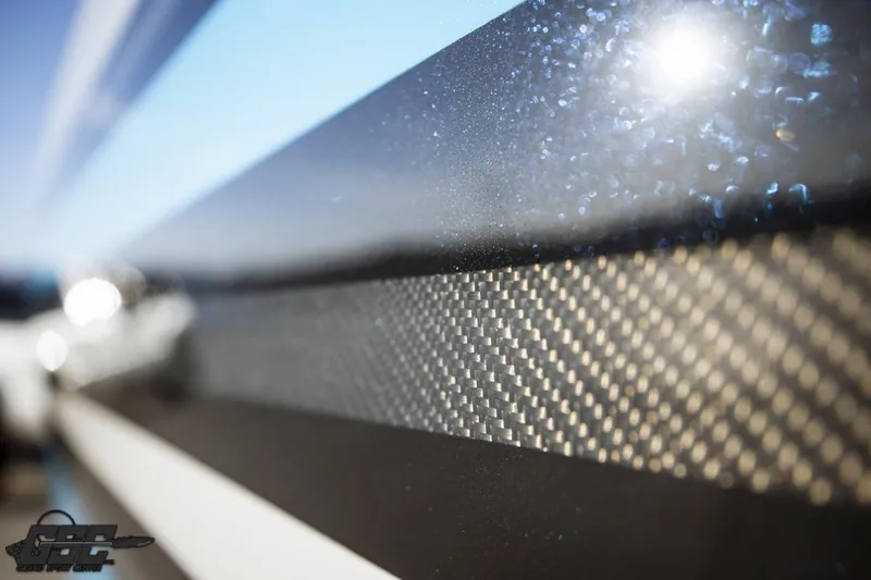 Slide: The Image of Close-up of 2025 Interceptor 36 GTC's sleek carbon fiber detailing under sunlight. - 25