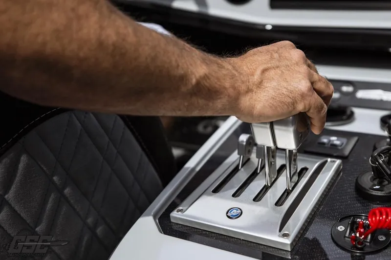 Slide: The Image of Hand operating throttle controls on 2025 Interceptor 36 GTC boat dashboard. - 55